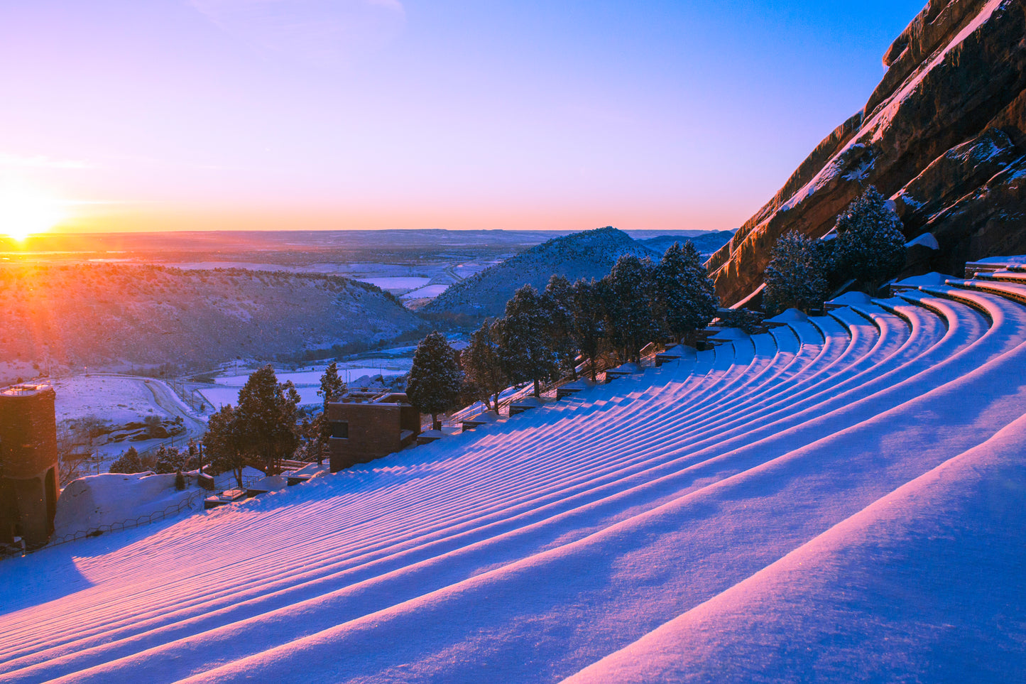 A canvas wall art print featuring a mountain landscape with a sunrise, predominantly in shades of pink and purple.